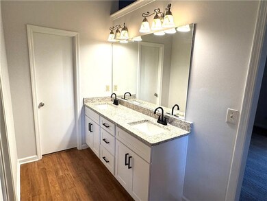 Bathroom featuring wood finished floors and double vanity