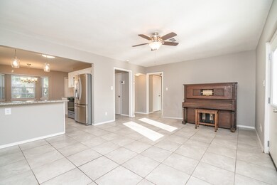 The front door and foyer lead directly into the heart of this home where you'll find an open concept family room with fresh neutral paint, easy to maintain ceramic tile flooring, and a seamless transition into the peninsula kitchen with breakfast bar seating.