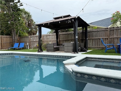 View of swimming pool with a gazebo, a fenced back