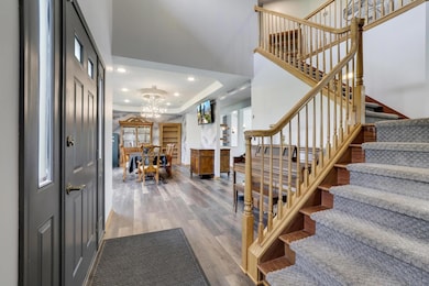 Grand staircase with open railings creates a stunning focal point in the entry.