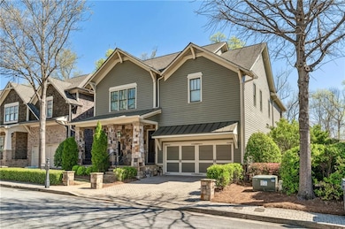 View of front of property with decorative driveway, a garage, a standing seam roof, and metal roof