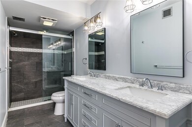 Master Bathroom with marble counter top, wood cabinet and upgraded shower with glass door.