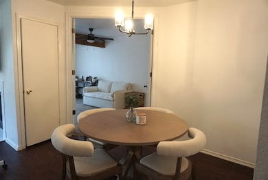 Dining space with a chandelier, dark wood finished floors, and a ceiling fan