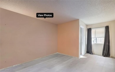 Spare room with a textured ceiling and light wood-