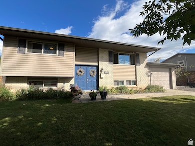 View of front of home featuring a front yard, brick siding, and an attached garage