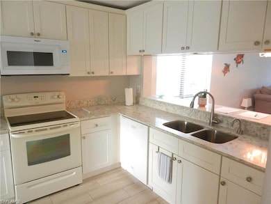 Kitchen featuring white cabinetry, sink, light sto