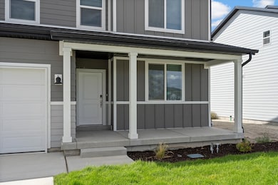 **DISCLAIMER - INTERIOR & EXTERIOR options may vary. (Grass is not included) Doorway to property with board and batten siding, a garage, and a porch