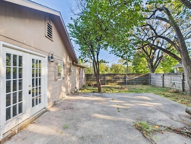 Fenced backyard with french doors and a patio area