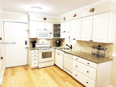 Kitchen with dark stone counters, white appliances