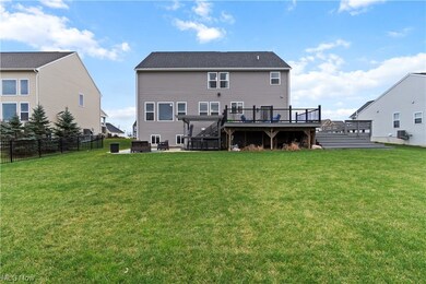 Rear view of house featuring a lawn and a wooden deck, patio and hot tub.