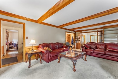 Living room with carpet, beamed ceiling, wainscoti