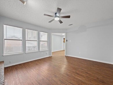 Spare room featuring ceiling fan, dark wood-style