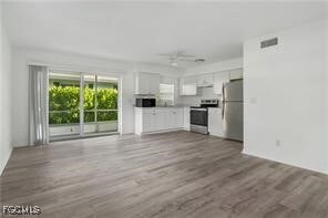 Unfurnished living room with dark wood finished floors and ceiling fan