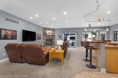 Living room featuring light carpet, recessed lighting, a bar, a fireplace, and light tile patterned floors