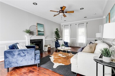 Alternate view of the living room highlighting the fireplace focal point, warm hardwoods, and generous wall space for versatile furniture layouts