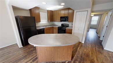 Kitchen with dark wood finished floors, black app