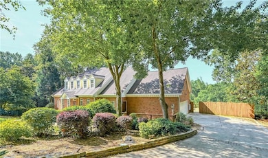 View of front of house featuring brick siding, driveway, and an attached garage