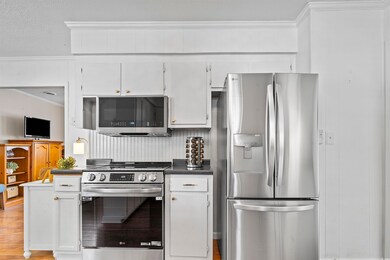 Kitchen featuring dark countertops, light wood-sty