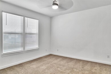 Empty room with carpet, a ceiling fan, and baseboa