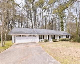 Ranch-style house featuring a garage, aphalt drive