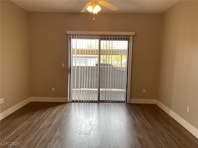 Spare room with dark wood finished floors and a ceiling fan