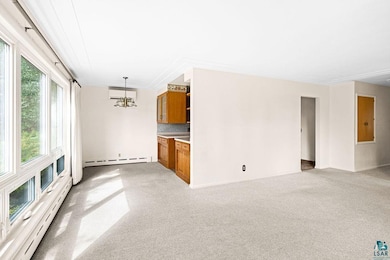 Unfurnished living room featuring a baseboard heat