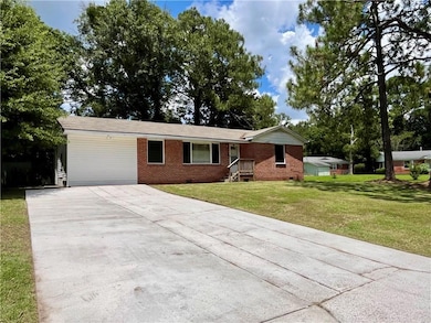 Single story home featuring crawl space, driveway, a front lawn, and brick siding