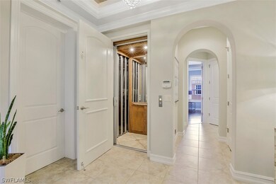 Hall featuring light tile flooring and crown molding