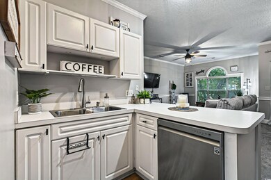 Kitchen with dishwasher, a sink, a peninsula, open shelves, and a ceiling fan