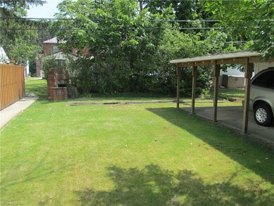 Back yard view with a stone grill/fire pit.