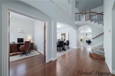Foyer with a towering ceiling and wood flooring