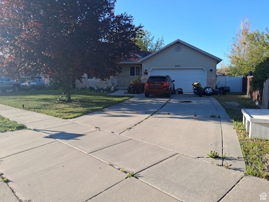 Ranch-style house featuring a garage, fence, driveway, and a front lawn