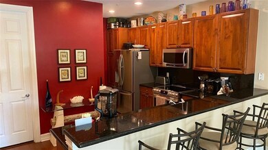 The kitchen features cherry wood cabinets, black g