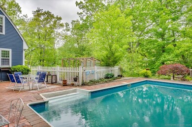 Enjoy easy indoor-outdoor living with a pool and brick patio directly off the kitchen, complemented by a sunlit vegetable garden nearby.