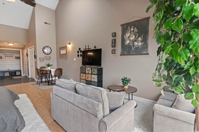 Living room with high vaulted ceiling and hardwood