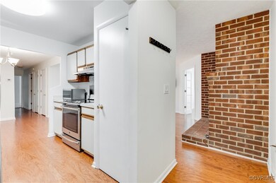 Kitchen with white cabinetry, light hardwood / woo