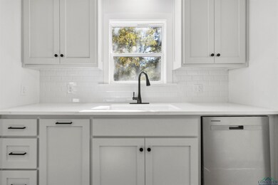Kitchen featuring white cabinets, tasteful backspl