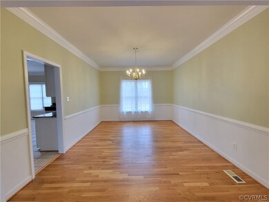 Dining Room with crown molding and chair railing