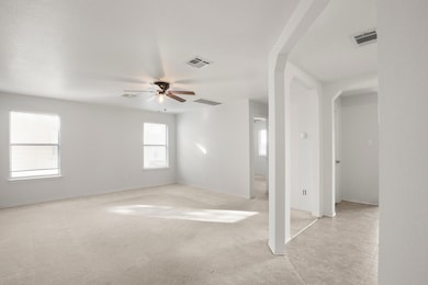 Empty room with arched walkways, light carpet, an