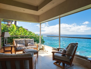 The primary bedroom suite opens onto this fabulous oceanfront covered lanai for morning coffee