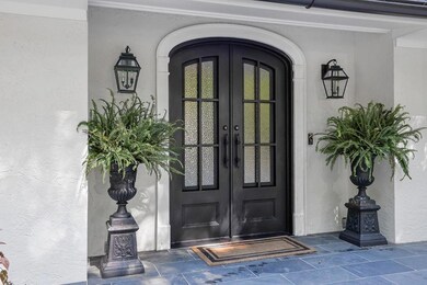 View of exterior entry featuring french doors and stucco siding