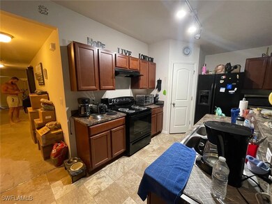 Kitchen with rail lighting, black appliances, and