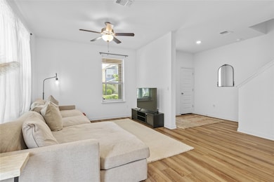 Living room with baseboards, a ceiling fan, wood 