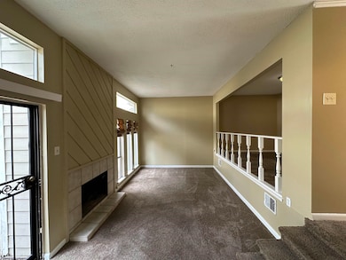 Unfurnished living room featuring carpet floors, plenty of natural light, a textured ceiling, and a fireplace