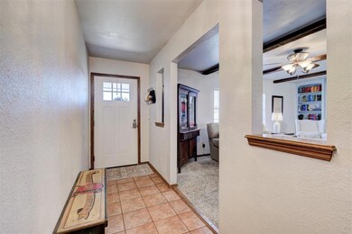 Foyer with baseboards, ceiling fan, beam ceiling, 