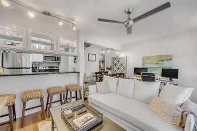 Living room with track lighting, ceiling fan, and