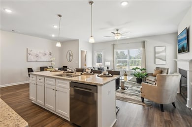 Kitchen featuring open floor plan, a sink, dark wo