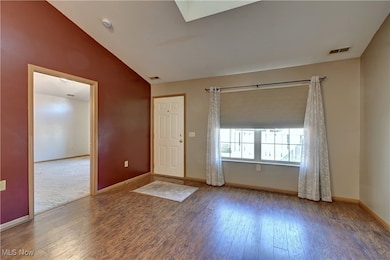 Entryway featuring a skylight, hardwood / wood-style floors, and vaulted ceiling