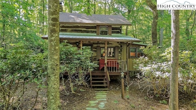 Log cabin in a wooded setting.