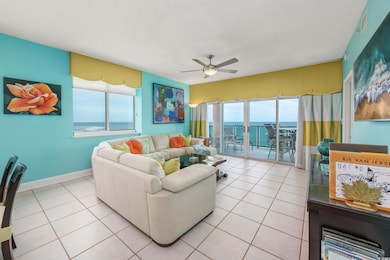 Living room featuring a ceiling fan, a water view, light tile patterned floors, and a textured ceiling